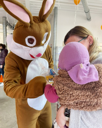 Osterhase übergibt einem Baby das Ostergeschenk