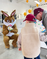 Osterhase präsentiert sein Ostergeschenk einem Jungen