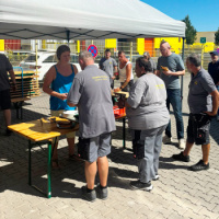 Mitarbeiter aus allen Abteilungen gemeinsam vor der Grillstation