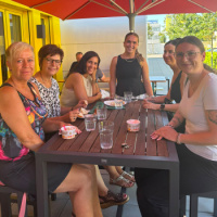 Mitarbeiterinnen aus verschiedenen Abteilungen gemeinsam am Tisch auf der Terrase von "Bistro Connect"
