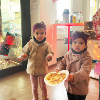 Zwei kleine Mädchen, die ihre frisch gebackenen Waffeln halten