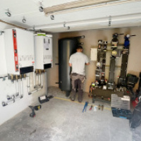 Wärmepumpenkaskade: ein Mitarbeiter installiert die Heiztechnik 