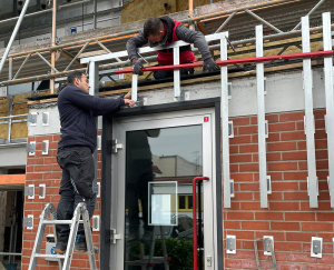 Bauarbeiter arbeiten an der Fassade am Eingang des Gebäudes von Friedrich Friedrich Bauarbeiter arbeiten an der Fassade am Eingang des Gebäudes von Friedrich Friedrich