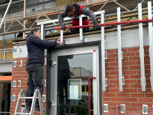 Bauarbeiter arbeiten an der Fassade am Eingang des Gebäudes von Friedrich Friedrich